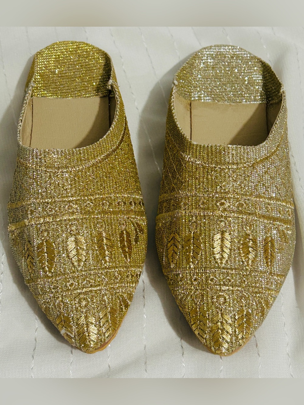 Moroccan babouche slippers adorned with intricate embroidery and a pointed toe.